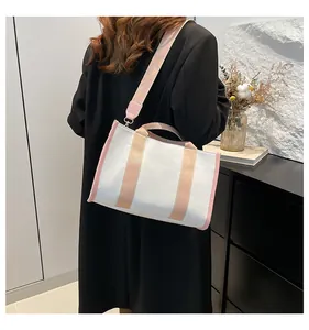 Modern canvas tote bag shown as shoulder bag with wide pink strap and minimalist decor