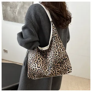 Sac fourre-tout à motif léopard avec bordure blanche porté par un mannequin