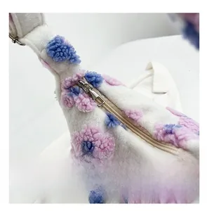 Detail shot of smooth silver zipper on white plush tote bag with colorful 3D flower pattern