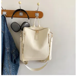 Detail eines cremefarbenen Damenrucksacks mit Kieselstruktur und goldfarbenen Reißverschlüssen