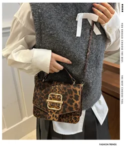 Détail d'un petit sac carré à imprimé léopard avec boucle dorée et texture en simili cuir