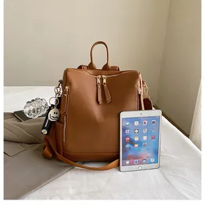 Brauner Lederrucksack Innenkapazität mit iPad-Größenvergleich und Blumenanhänger