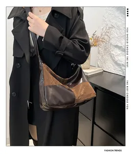 Detail of contrast stitch tote bag showing glossy texture on a long coat model