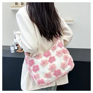 Close-up of fluffy white plush tote bag with pink floral embroidery on a model shoulder