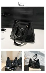 Detail of black glossy wrinkled leather tote with golden buckle and zipper closure
