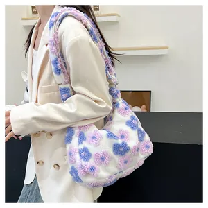 Close-up of floral plush tote bag showing soft pink and blue textures with a beige blazer