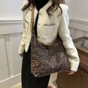 Grand sac hobo léopard avec bandoulière réglable porté par un mannequin dans un décor épuré
