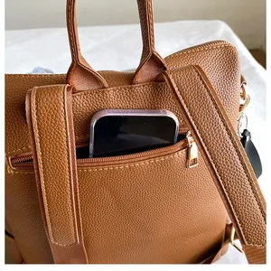 Detailansicht der Rückseite des braunen PU-Rucksacks mit Diebstahlsicherung und Smartphone