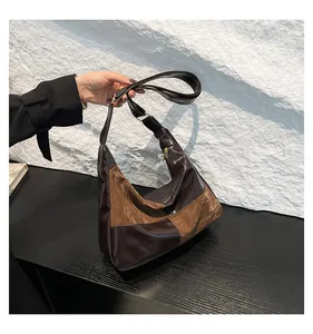 Detail of color-block hobo bag showing pleated brown faux leather and golden zipper