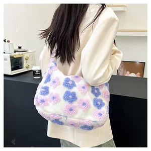 Detail of soft white plush tote bag with pink and blue floral patterns on a model's shoulder