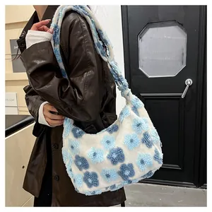 Detailed texture of white plush tote bag with blue floral patterns on a faux fur shoulder bag