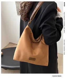 Brown faux suede tote bag with leather strap and fashion patch on casual shoulder look