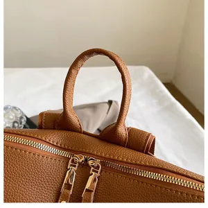 Details des braunen Lederrucksacks mit strukturierter Oberfläche und goldenen Reißverschlüssen