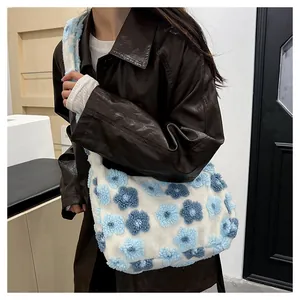 Detail of plush floral tote bag showing 3D blue flower texture and wide fuzzy strap