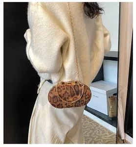 Detail of vintage leopard print crossbody bag with gold bow clasp and chain strap