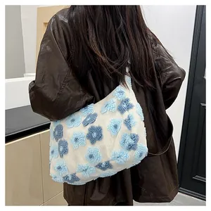 Close-up of fluffy white plush tote bag with 3D blue floral patterns on a model