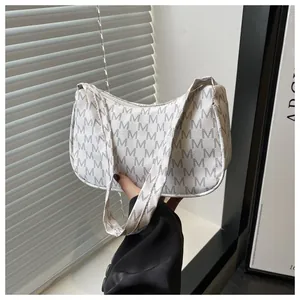 Detail showing the white and gray letter M pattern and PU leather texture of the underarm bag