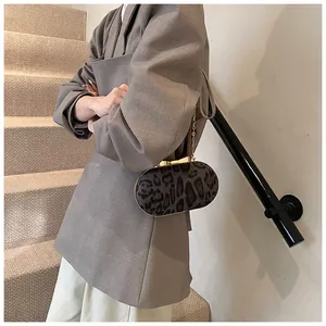 Detailed side view of leopard print shoulder bag with gold chain strap on a blazer