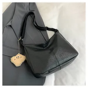Black soft leather oversized tote bag with pleat texture and plush smiley charm