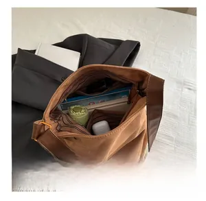 Macro view of brown suede tote bag interior with striped lining and large capacity storage