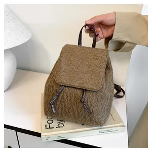 Gros plan d'un sac à dos en faux mouton marron avec cordon et finition texturée
