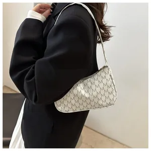 Macro shot of off-white crescent underarm bag with repeated M-letter monogram pattern