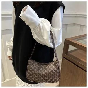 Retro brown crescent shoulder bag with M pattern shown on a model in a stylish setting
