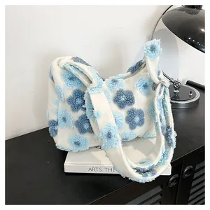 Close-up of white plush tote bag with blue floral patterns on a display shelf