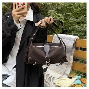 Close-up of brown nylon shoulder bag with silver hardware on a wooden bench