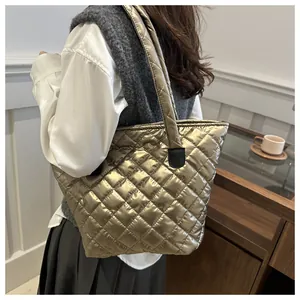Detalle del bolso tote acolchado oro champán con brillo metálico y gran capacidad total