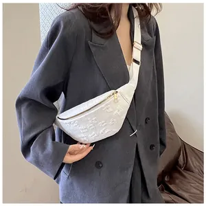 White fashion chest bag for women with textured surface shown on a model