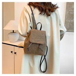Détail de la texture en laine et fermeture à cordon sur un sac à dos d'hiver marron