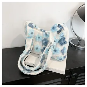 Close-up of white and blue plush flower pattern on a soft fleece tote shoulder bag