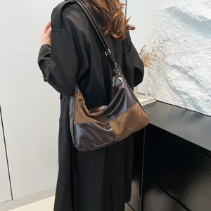 Minimalist brown patchwork hobo bag in leather and suede shown on shoulder by a model