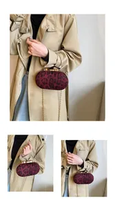 Detail of leopard print evening clutch with gold ring handle and chain strap