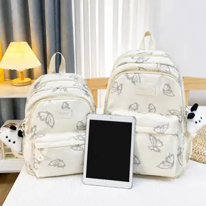 Comparación de tamaños de mochilas de lona blanca con estampado de mariposa y panda
