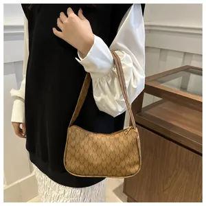 Close-up of vintage brown crescent hobo bag with M-pattern monogram on female model