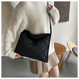 Detail view of black quilted nylon crossbody bag with classic diamond stitching pattern