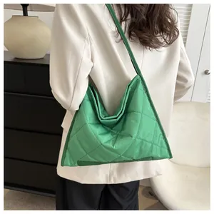 Macro detail of vibrant green quilted nylon shoulder bag with a soft puffy texture