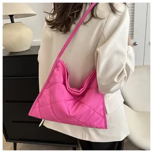Close-up of vibrant pink quilted hobo bag with diamond stitching on model back