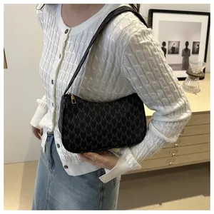Detail of black monogram crescent shoulder bag shown on model for size and style reference