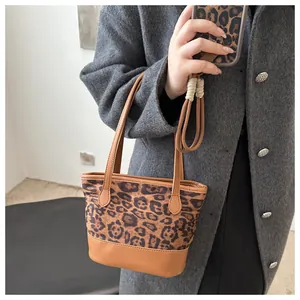 Close-up of stylish leopard print handbag set with matching phone case and woven strap
