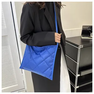Model wearing a bright royal blue quilted rhombic crossbody bag with a casual outfit