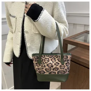 Fashionable leopard print tote bag with olive green leather trim worn by model