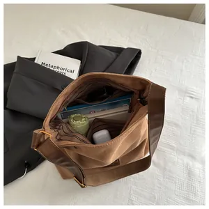 Open brown suede tote bag showing striped lining and spacious interior with pocket