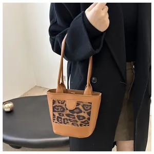 Detail of vintage brown leather tote bag featuring stylish leopard print panel