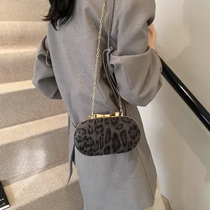 Elegant leopard print crossbody bag with gold bow clasp and metal chain strap for women