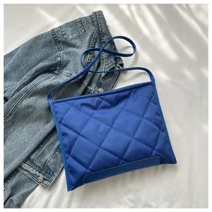 Close-up of blue quilted rhombic pattern on shoulder bag with silky nylon texture