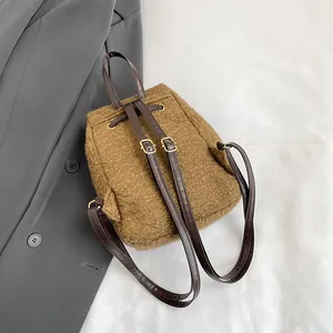 Sac à dos marron en laine bouclée pour femme avec bretelles en cuir et boucles dorées