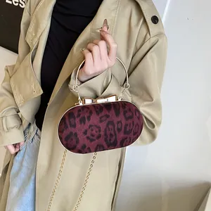 Burgundy leopard print crossbody bag with gold bow clasp and metal chain strap